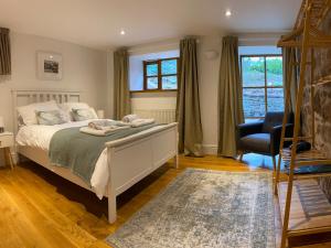 a bedroom with a bed and a chair and windows at Ty Bont in Wrexham