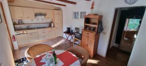 eine Küche mit einem Tisch und Stühlen sowie einem TV in der Unterkunft Paradies 2 Castellberg-Jakobsweg in Kastelhof