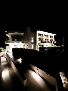 un edificio con luces delante de él por la noche en Gmare, en Gerakini