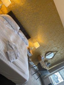 1 dormitorio con cama y mesa con espejo en The Old Ship, en Newbiggin-by-the-Sea