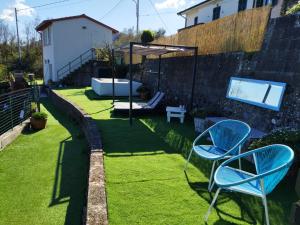 a yard with two blue chairs on the grass at AMPHIORAMA in La Spezia