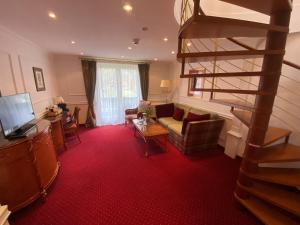 a living room with a spiral staircase and a living room at Hotel Alpenhof Bayrischzell in Bayrischzell