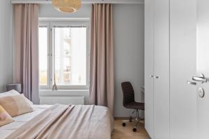 1 dormitorio con 1 cama, 1 silla y 1 ventana en Amazing views by Finnoo metro, en Espoo