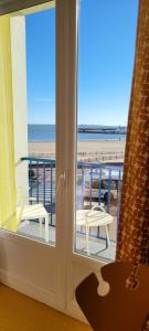 a room with a view of the beach from a window at Seakub hotel in Royan