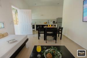 uma sala de estar com mesa e cadeiras e uma cozinha em Nasim Condo Hotel con acceso BEACH CLUB GRATIS, metros 5th AVENIDA em Playa del Carmen