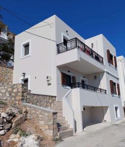 a white building with a balcony on top of it at Villa Infinity in Menetaí