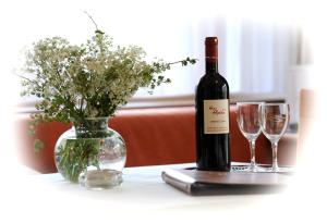 - une bouteille de vin et deux verres sur une table dans l'établissement Haus Alpina, à Au im Bregenzerwald