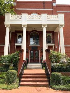 un edificio in mattoni rossi con colonne e una porta di The James Madison Inn a Madison