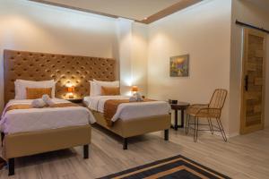 um quarto de hotel com duas camas e uma mesa em The Mayana Resort em Dauis