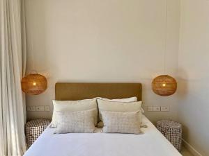 a bedroom with a bed with two lamps and two pillows at Exclusive beachfront penthouse in Belle Mare +7 photos