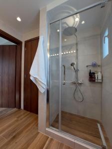 a bathroom with a shower with a glass shower stall at Villa Infinity in Menetaí