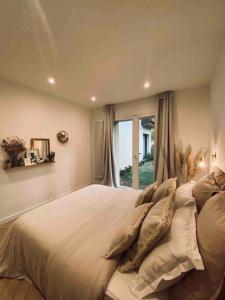 a bedroom with a large bed with a window at Chambre indépendante avec sdb et toilettes privées dans une maison en forêt proche du golf et de la plage Entree indépendante avec acces privé in Le Touquet-Paris-Plage