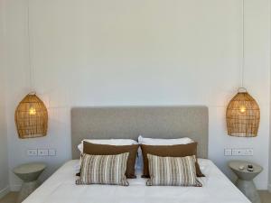 ein Schlafzimmer mit einem Bett mit zwei Kissen und zwei Lichtern in der Unterkunft Exclusive beachfront penthouse in Belle Mare