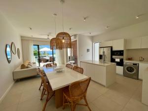 a kitchen and living room with a table and chairs at Exclusive beachfront penthouse in Belle Mare