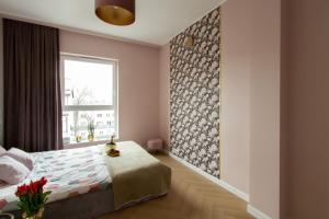 a bedroom with a bed and a window at Nowy Apartment przy Placu Szembeka in Warsaw