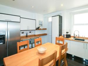 a kitchen with a wooden table with chairs and a sink at 11 Magdalene Road in Torquay