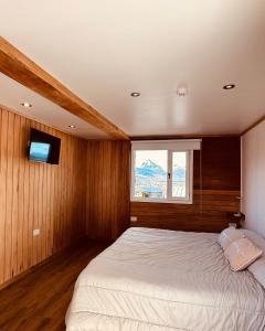 - une chambre avec un grand lit et une fenêtre dans l'établissement Gi 's House, à Ushuaia
