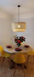 a dining room table with plates and flowers on it at Casa Vilas, Santiago de Compostela in Santiago de Compostela +9 photos