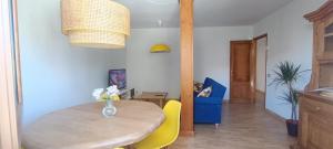 uma sala de jantar com uma mesa de madeira e cadeiras amarelas em Casa Vilas, Santiago de Compostela em Santiago de Compostela