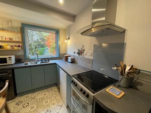 cocina con fogones y fregadero en One bed cosy Highland cottage near Beauly, en Beauly