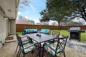 a table with chairs and a grill in a backyard at Stay Awhile! Pool Table+ Fire-pit+ 4 bedroom+ 2 baths+ Game-room! in Dallas