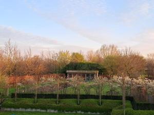 un jardín con un edificio con techo de césped en Domein Den Buiten Bed And Breakfast DnD en Sint-Niklaas