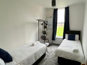 two beds in a room with a window at Sandy shoes in Scarborough