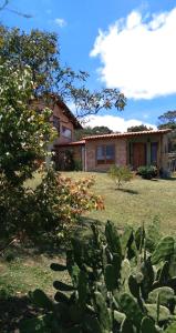 una casa con un cactus delante de ella en Pousada Canto da Lua - charme e vista incrível en Carrancas