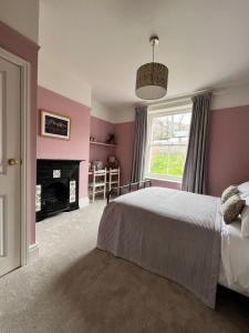 a bedroom with a bed and a fireplace and a window at Riversdale House Bed & Breakfast in Llangollen