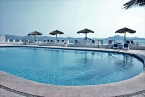 a large swimming pool with chairs and umbrellas at Condo in Puerto las Hadas in Manzanillo