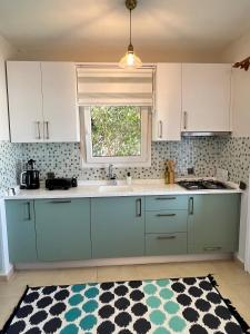 a kitchen with blue cabinets and a window at 2+1 House in Bodrum center with sea view and big private garden in Bodrum City