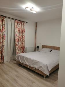 1 dormitorio con 1 cama grande y cortinas en Pensiunea La Nenea Iancu, en Pianu de Sus