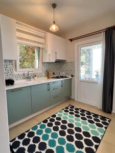 uma cozinha com armários azuis e um tapete preto e branco em 2+1 House in Bodrum center with sea view and big private garden em Bodrum City