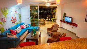 a living room with a blue couch and chairs at Condo in Puerto las Hadas in Manzanillo