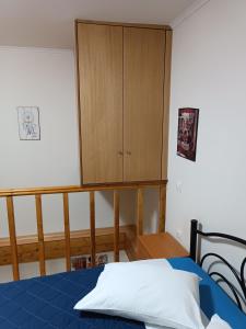 a bedroom with a bed and a cabinet at Two-storey maisonette next to the port in Mantoúkion