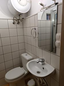 a bathroom with a toilet and a sink and a mirror at Two-storey maisonette next to the port in Mantoúkion
