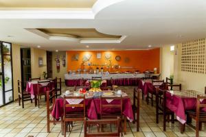 un restaurante con mesas y sillas con mantel púrpura en GB Hoteis Natal, en Natal