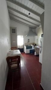 a large kitchen with a table and a refrigerator at Casa de Huéspedes Muñiz sobre parque de 1000m2, 1 dormitorio, 20m2 cubiertos, baño con ducha, pileta cilíndrica de 3x076 in Muñiz