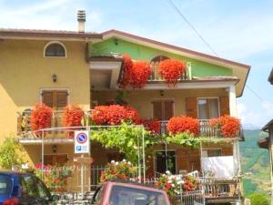 a house with flowers on the balconies of it at Cozy apartment in Prabione, 30 m², charming balcony in Campione del Garda
