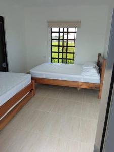 dwa łóżka w pokoju z oknem w obiekcie Casa Campestre Ibague con piscina - capacidad 15 personas w mieście Ibagué