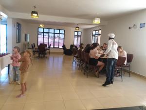 un groupe de personnes debout dans une pièce dans l'établissement 401 Restaurant & Accommodation, à Naivasha