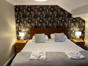 a bedroom with a large bed with towels on it at Bryn Noddfa in Morfa Nefyn