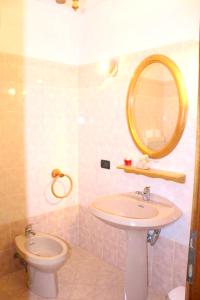 La salle de bains est pourvue d'un lavabo, d'un miroir et de toilettes. dans l'établissement 2 bedrooms apartement with furnished balcony and wifi at Prabione 8 km away from the beach, à Campione del Garda