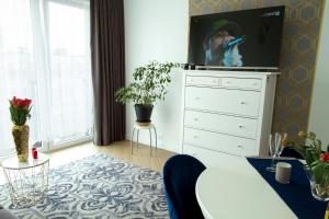 - un salon avec une commode et une télévision dans l'établissement Nowy Apartment przy Placu Szembeka, à Varsovie