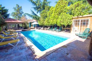 a swimming pool with chaise lounge chairs next to it at 10 bedrooms villa with private pool jacuzzi and enclosed garden at Sils in Sils