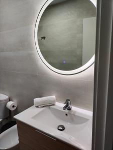 uma casa de banho com um lavatório e um espelho em Apartamento 1º linea playa Torrenueva, Motril, Granda em Torrenueva