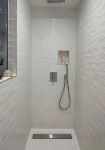 a white bathroom with a shower with a hose at Chambre indépendante avec sdb et toilettes privées dans une maison en forêt proche du golf et de la plage Entree indépendante avec acces privé in Le Touquet-Paris-Plage