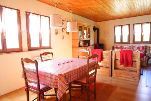 een eetkamer met een tafel, stoelen en ramen bij Petit chalet de montagne avec espace extérieur in Labaroche