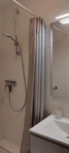 ein Bad mit einem Duschvorhang und einem Waschbecken in der Unterkunft Studio Quartier haut in Sète