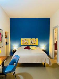 1 dormitorio con 1 cama grande y pared azul en L' estate di san Martino Room Rental - free park, en Asti